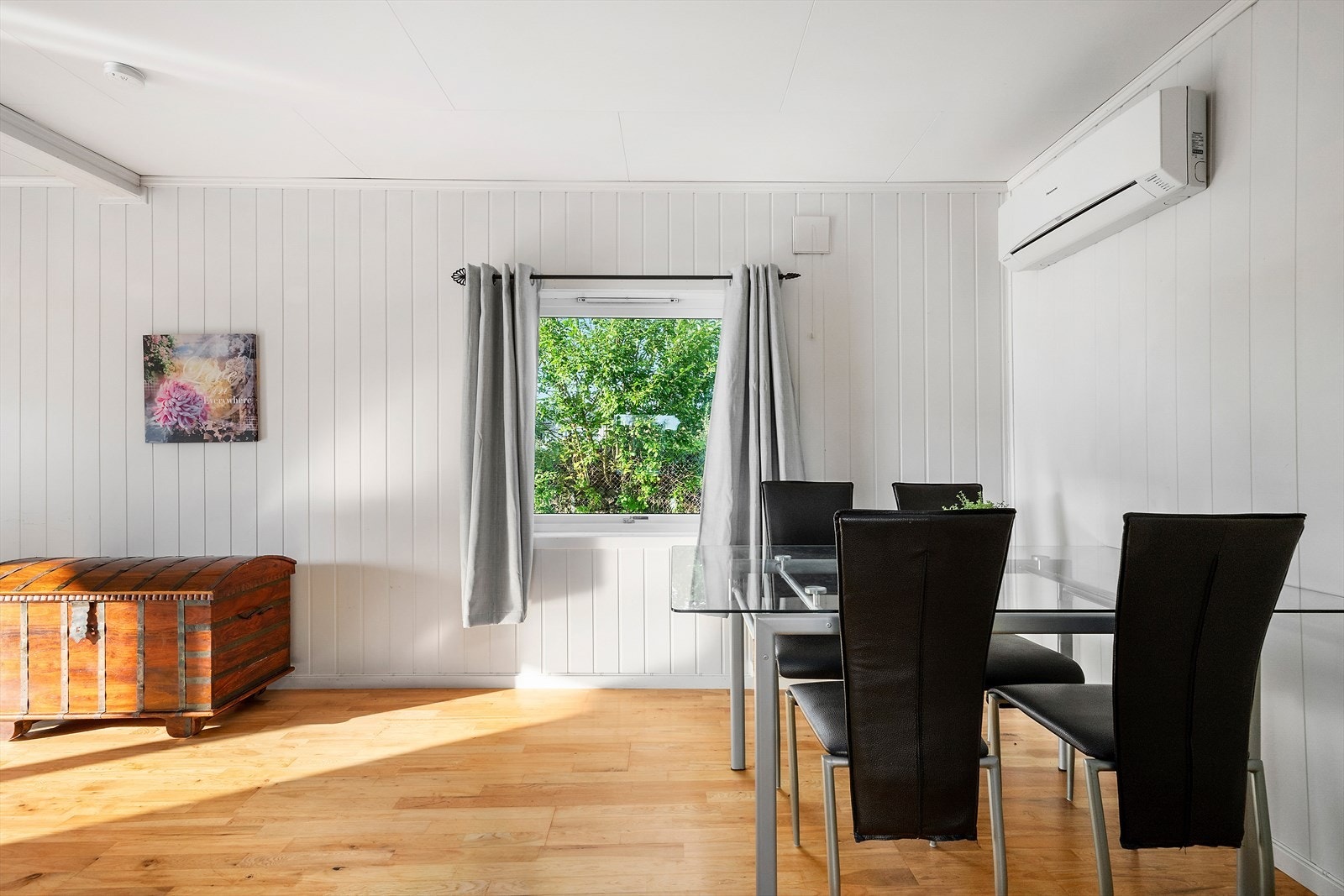 En koselig spisestue med glassbord og plass til fire personer. Store vinduer slipper inn rikelig med dagslys og skaper en lun atmosfære. Perfekt for både hverdagsmiddager og små sammenkomster. Galleribilde