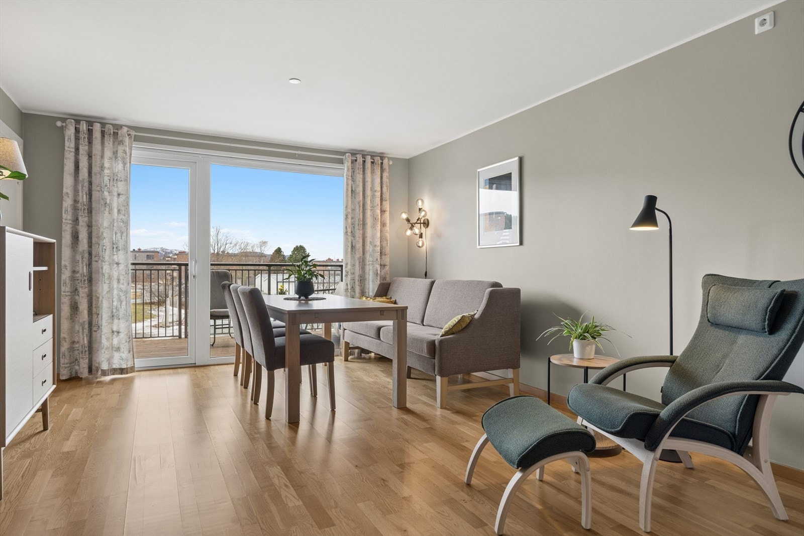 Stor og lys stue med store vindusflater som setter et luftig preg på leiligheten. Galleribilde