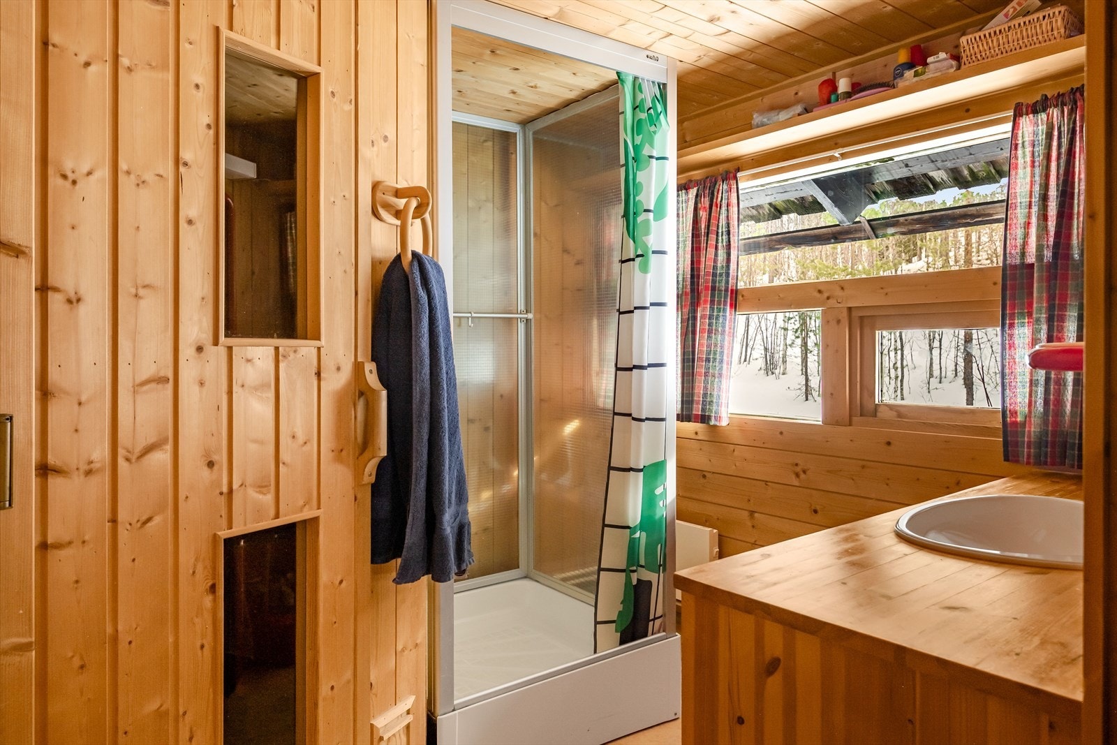 Baderom med dusjkabinett og servant på innredning samt badstue. Galleribilde