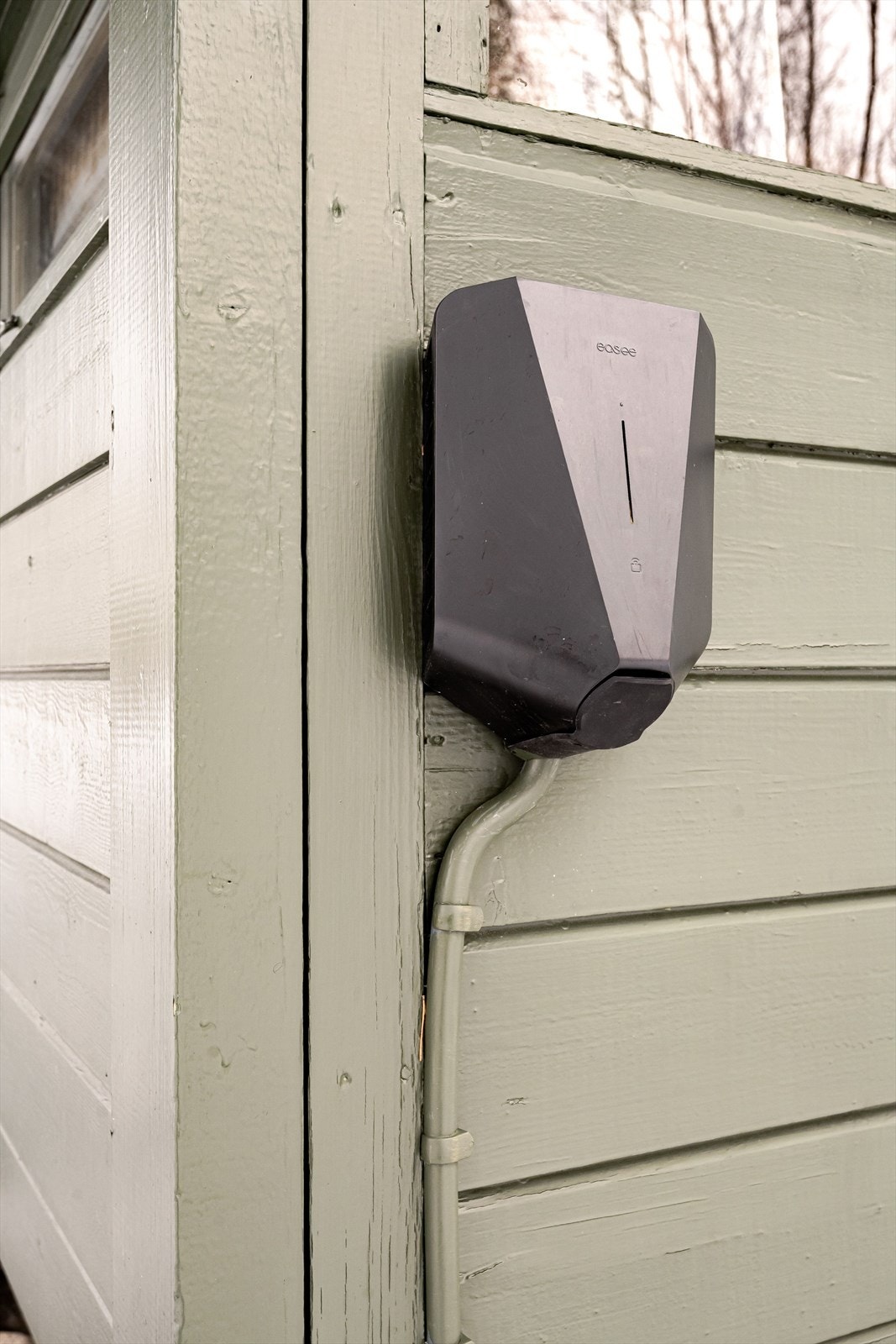 Det er montert elbil-lader på hytteveggen. Galleribilde