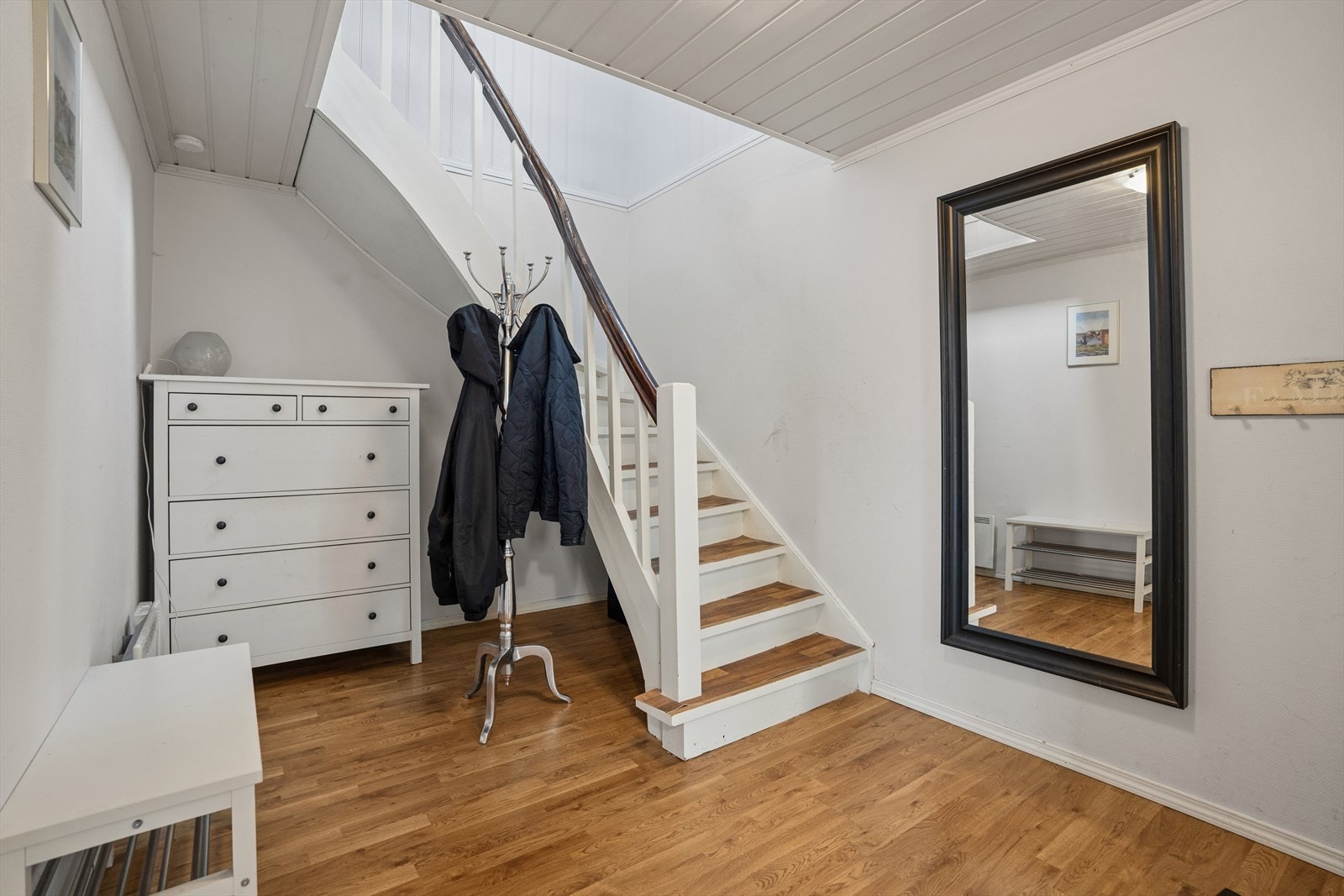 En lys entré ønsker velkommen og binder etasjene sammen. Det er god plass til garderobeløsninger under trappen. Galleribilde