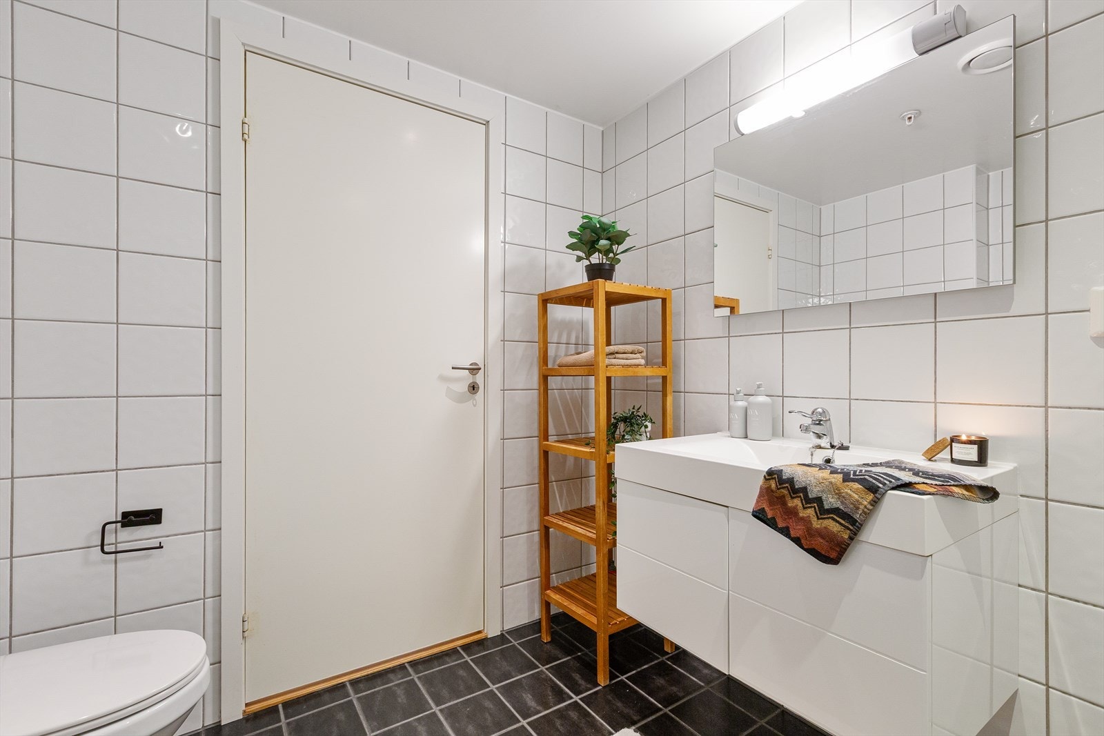 Baderommet er innredet med toalett, dusj, opplegg for vaskemaskin og baderomsservant. Galleribilde