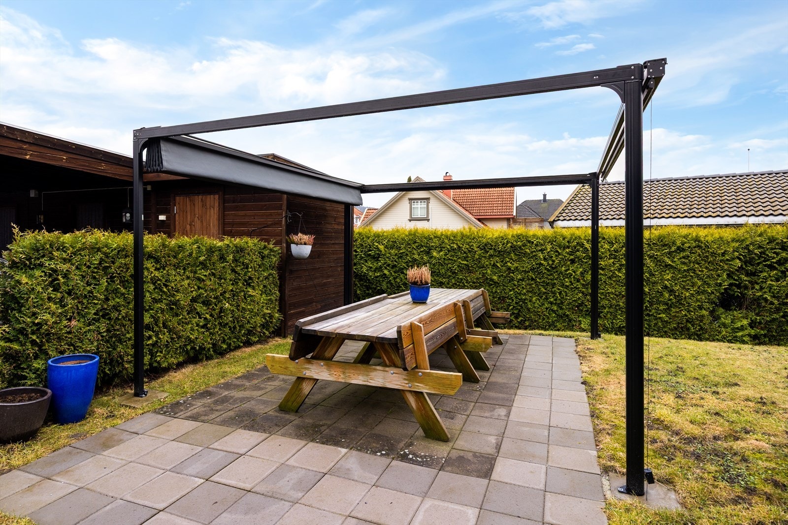 Ved gårdsplassen, mellom carportanlegg og boligen, er det opparbeidet en hyggelig uteplass med steinheller og sittebenker til felles bruk. Galleribilde