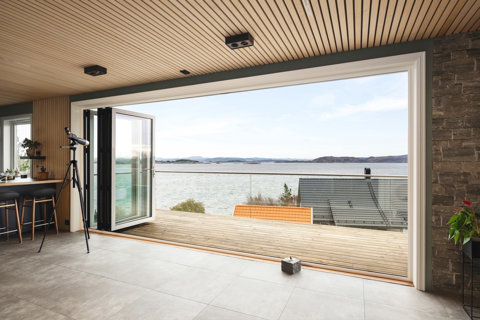 Fra stuen fører store skyvedører deg sømløst ut til den romslige terrassen, hvor du kan åpne opp og la inne- og uterom smelte sammen Galleribilde