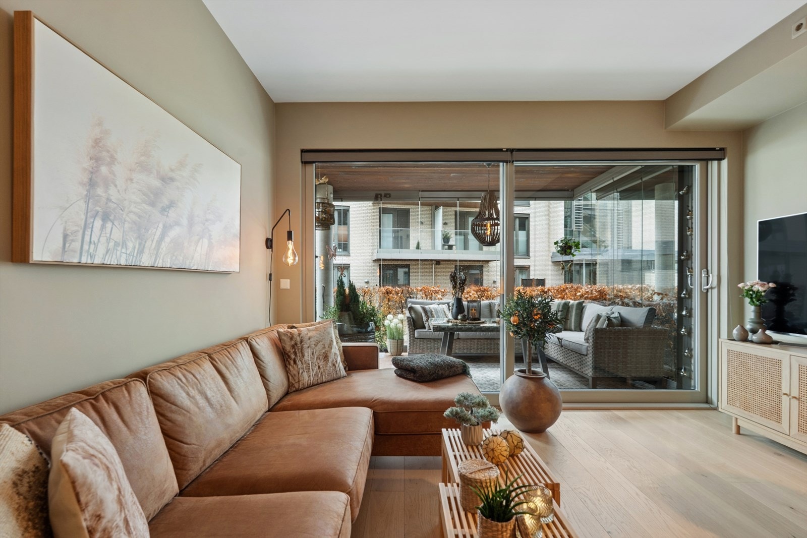 Den åpne stue- og kjøkkenløsningen gir en sosial sone med direkte utgang til en innglasset balkong på 10 m². Galleribilde