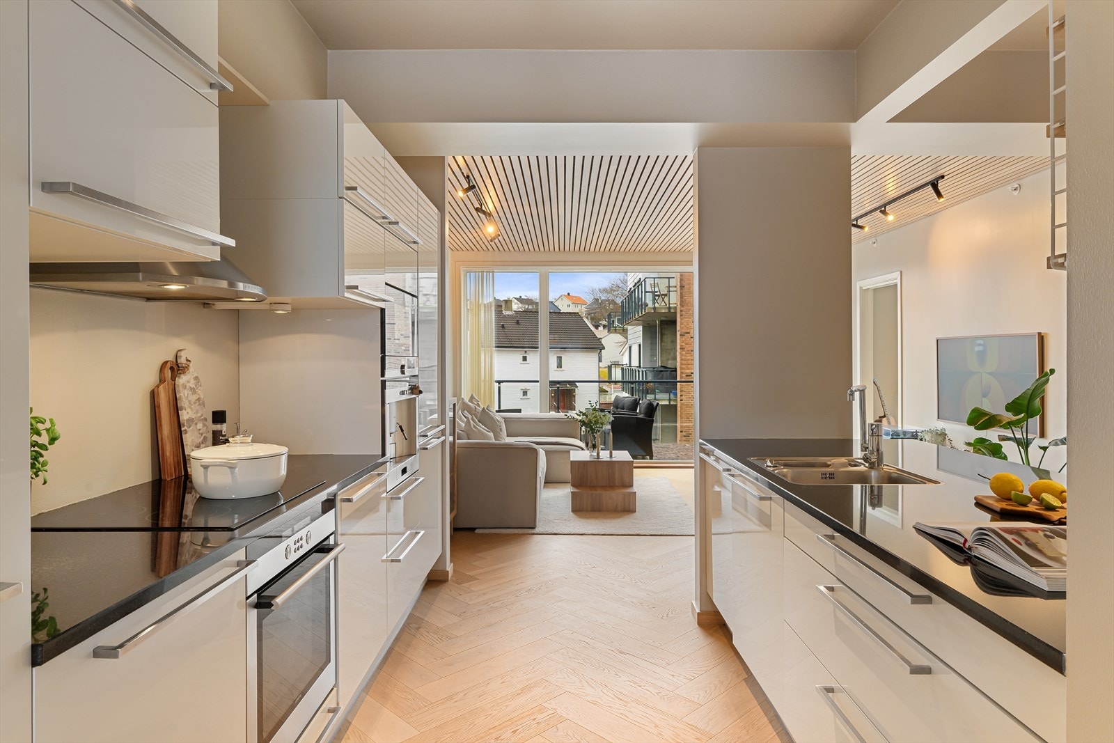 Lyst og fint kjøkken med flott kjøkkenøy og benkeplate i stein Galleribilde