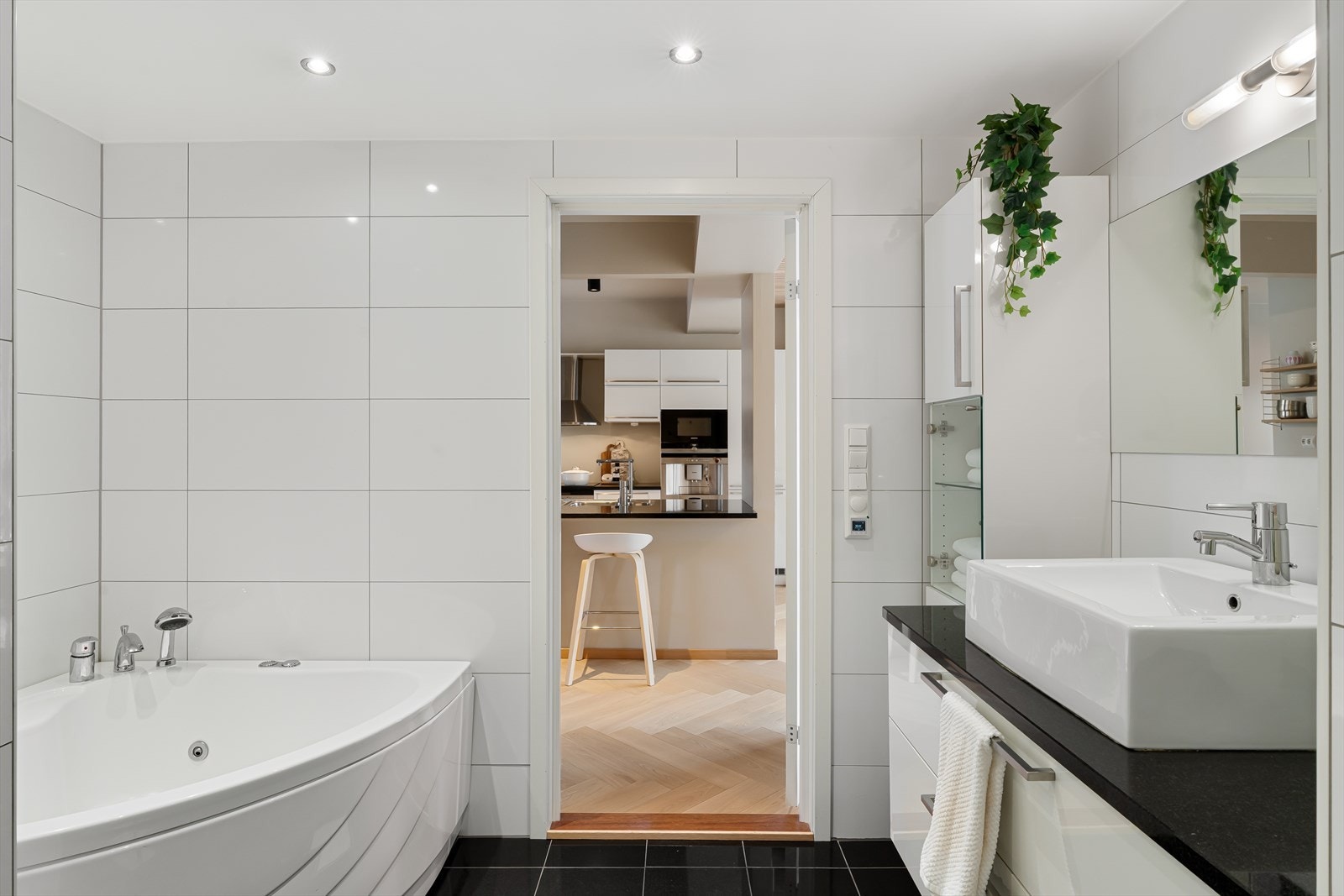 Badet er innredet med nedfelt servant, veggmontert toalett samt herlig boblebadekar Galleribilde