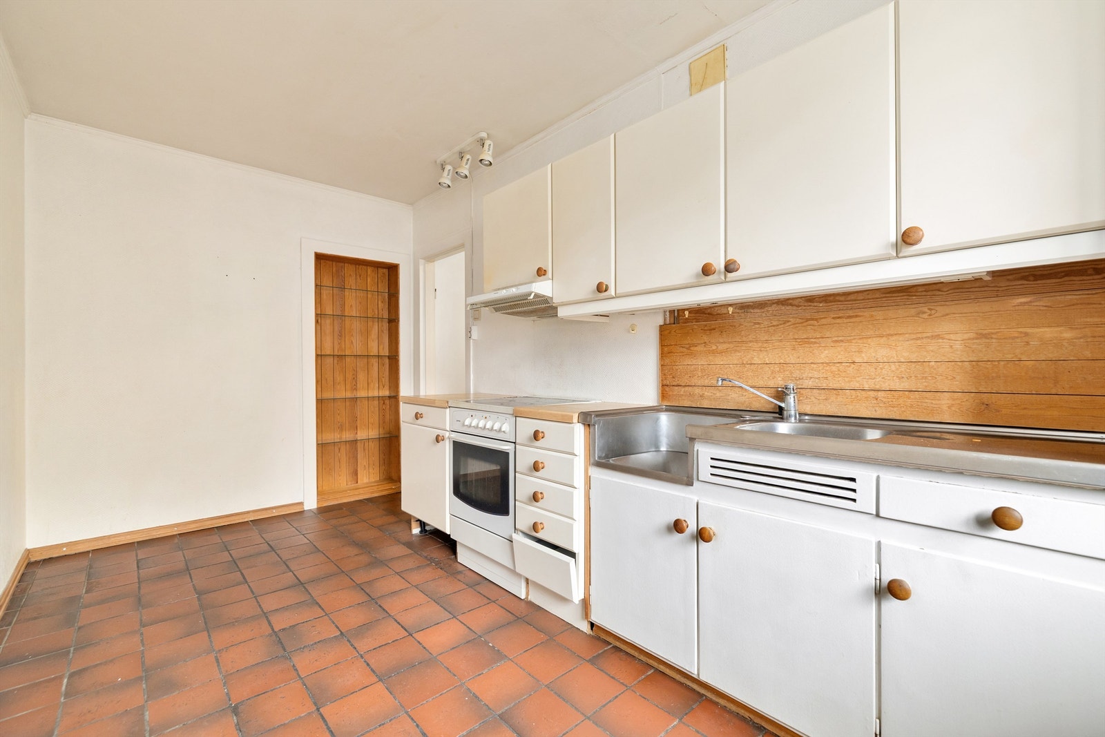 Innredning fra ukjent årstall. Glatte fronter. Benkeplate med laminert overflate. Kjøkkenvask med armatur. Stikkontakt over kjøkkenbenk. Galleribilde