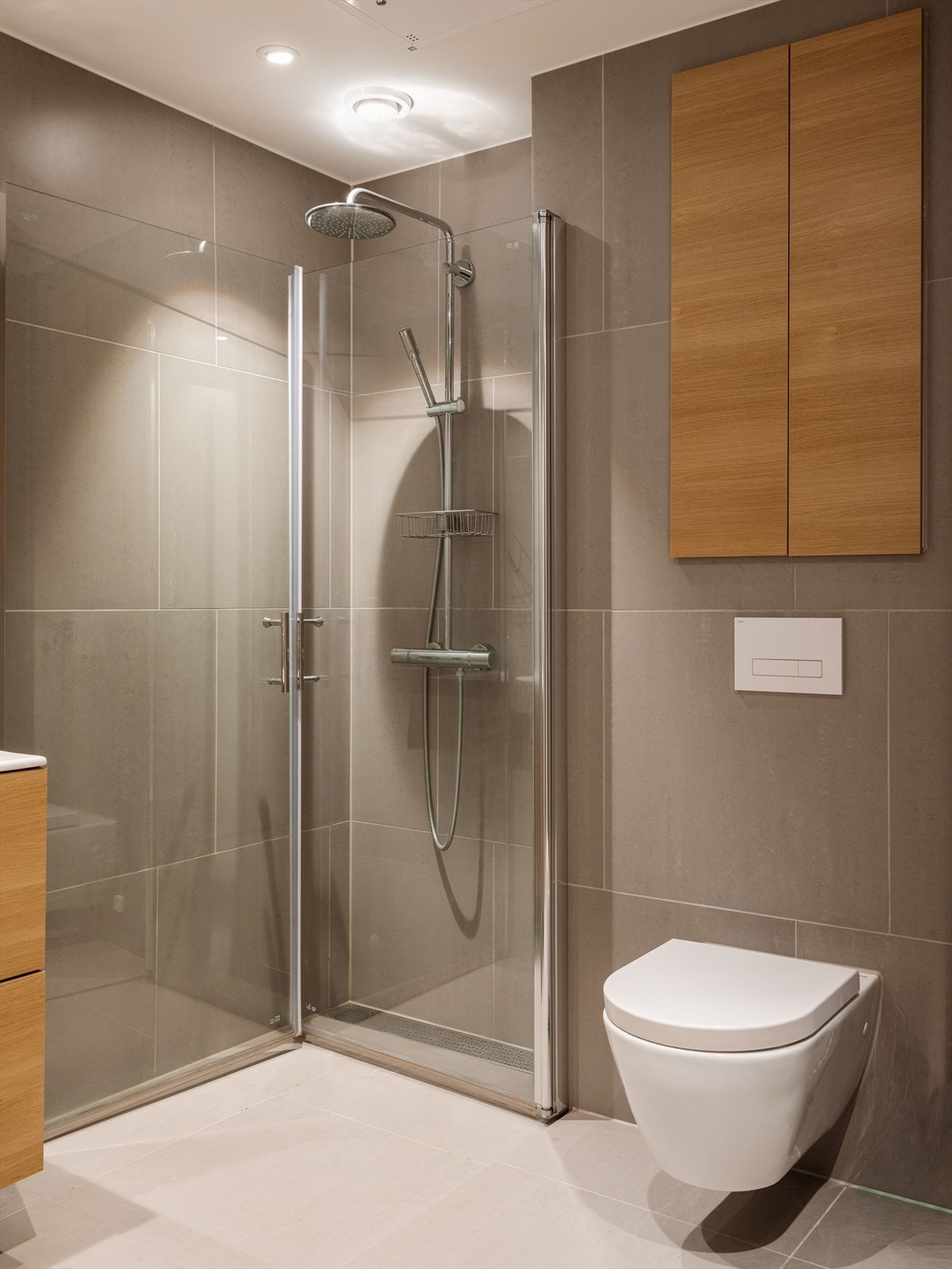 Romslig dusjplass på gulv bak dører i herdet glass. Galleribilde