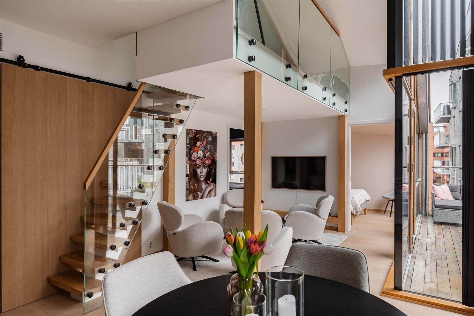 Oppholdsrommet fremstår som særdeles lyst og luftig, med imponerende takhøyde og store vindusflater som slipper inn rikelig med naturlig lys. Galleribilde