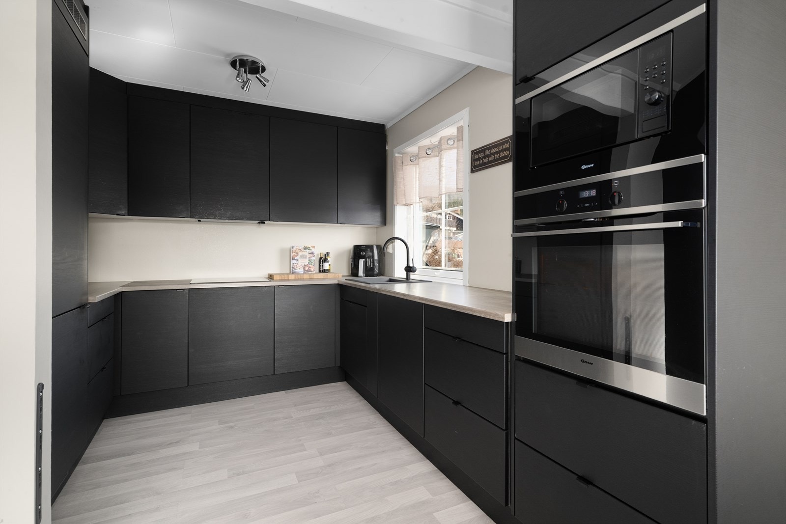 Kjøkkendelen har en lekker, takhøy innredning fra Systemkjøkken fra 2021 med slette fronter og laminat benkeplate med kompositt oppvaskkum. Galleribilde