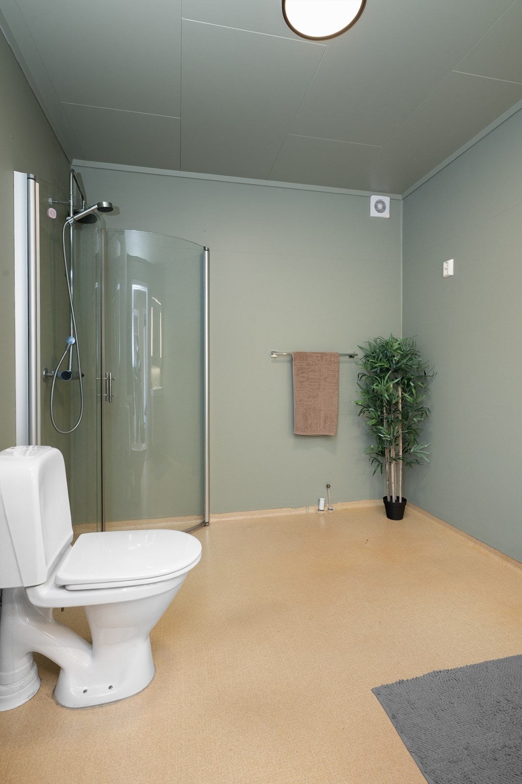 Badet har også toalett og dusjhjørne med innfellbare glassvegger. Det er varmekabler i gulv og elektrisk vifte i yttervegg. Galleribilde