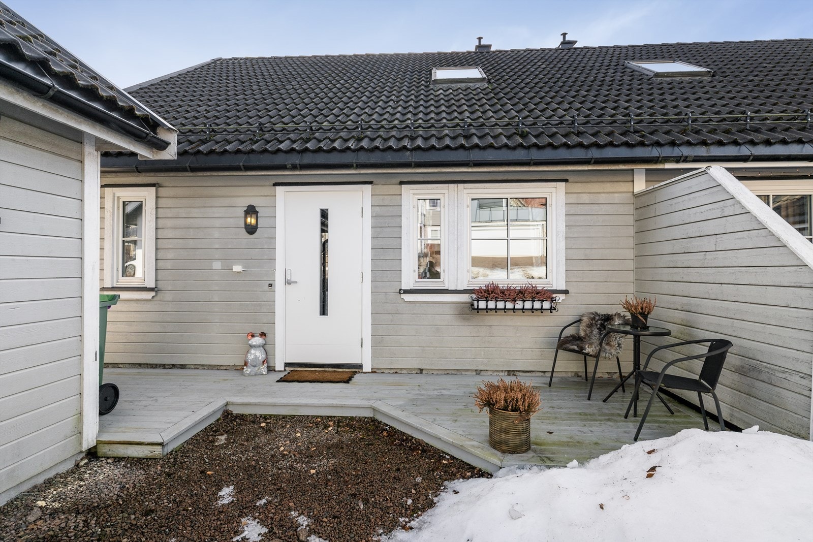 Boligen har et hyggelig inngangsparti med en koselig uteplass og tett le-vegg mot nabo. Galleribilde