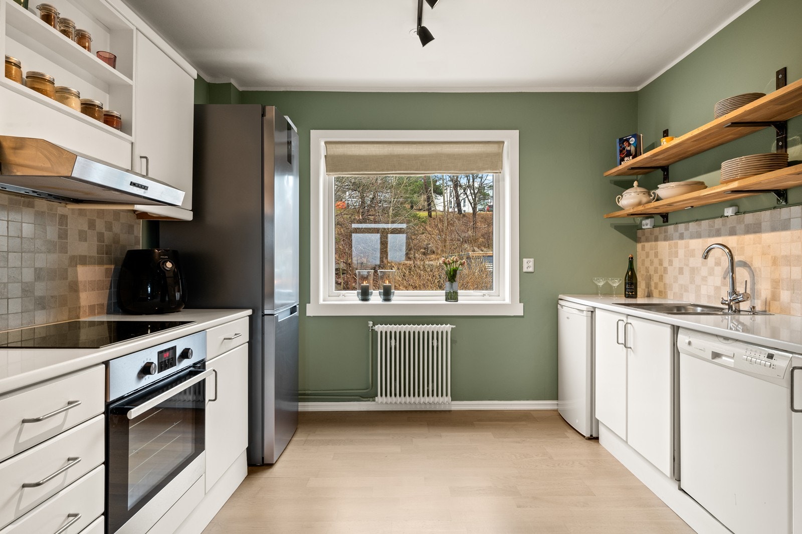 Kjøkkenet har en funksjonell innredning med slette fronter. Laminat benkeplate og integrert stekeovn med platetopp. Galleribilde