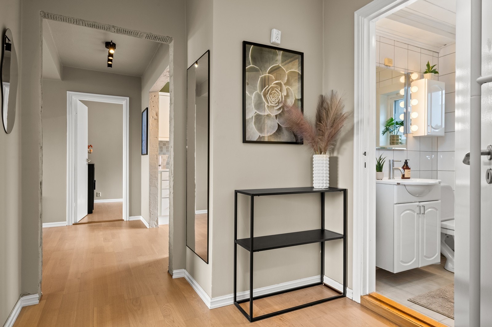 Fra gangen åpner leiligheten seg opp mot stuen. Dørene mellom gang, stue og kjøkken er fjernet for en luftig romfølelse. Galleribilde