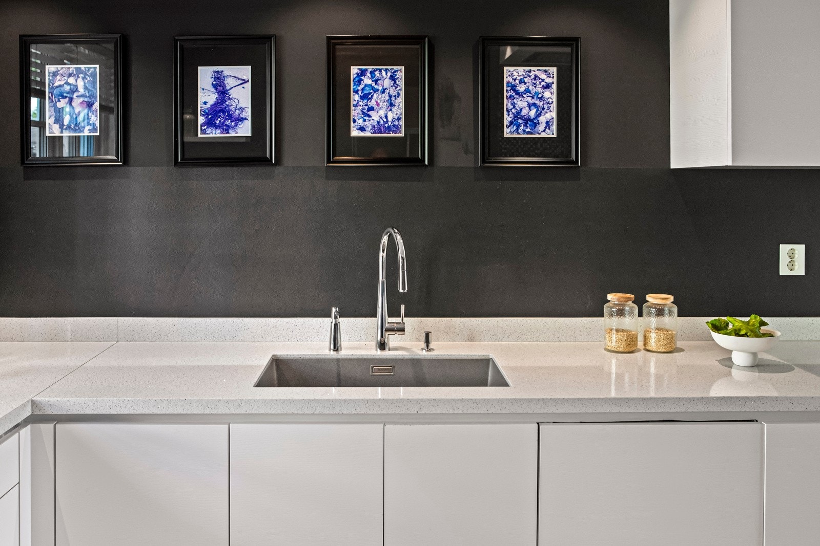 Innredningen imponerer med hvite, glatte fronter, takhøye skap og en lys benkeplate med underlimt stålkum. Galleribilde