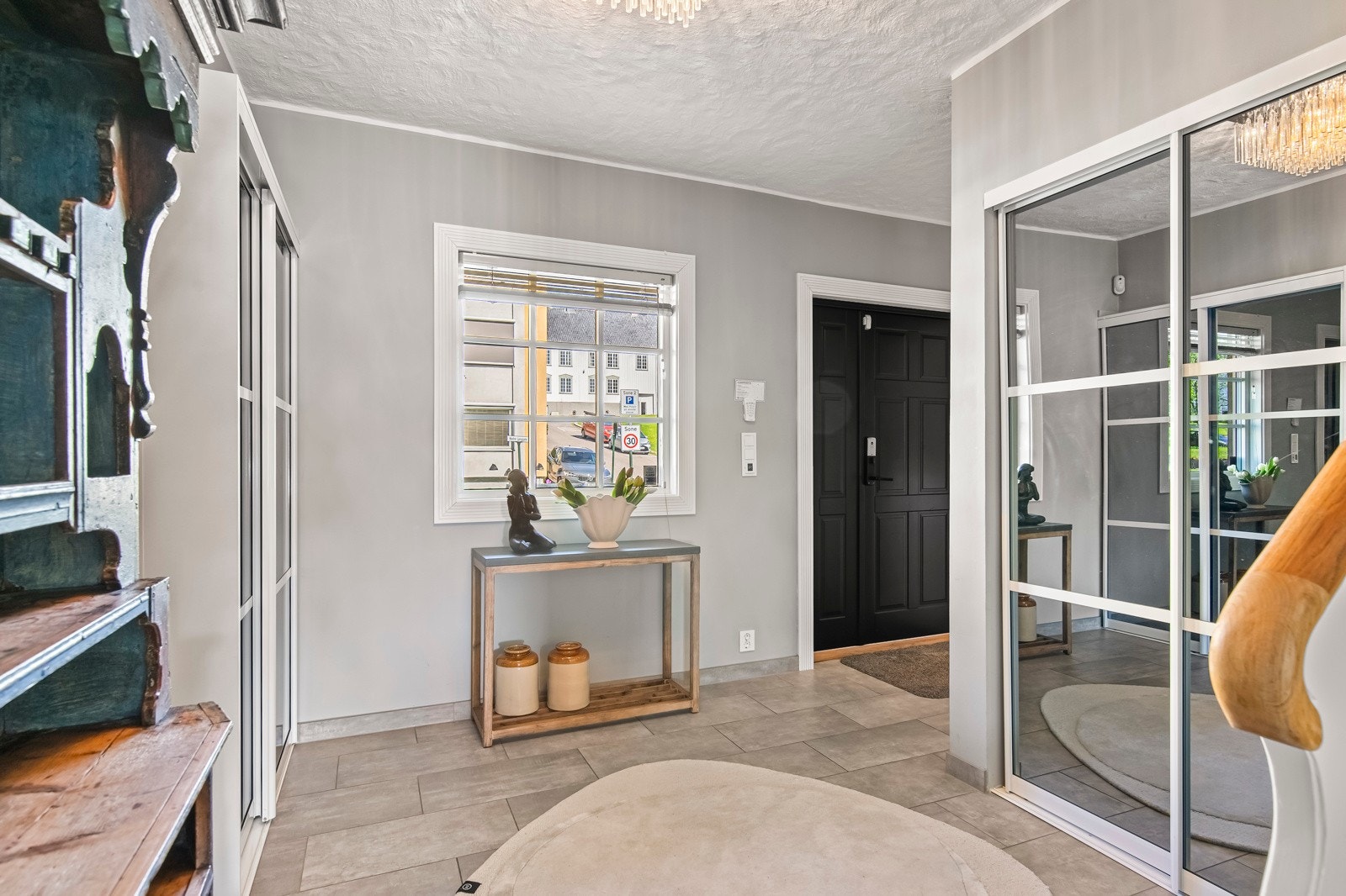 Når du trer inn, blir du møtt av en stor og innbydende hall som umiddelbart gir et fantastisk førsteinntrykk. Hallen har moderne, gråmalte vegger og matchende fliser på gulvet, som også har gulvvarme for ekstra komfort. Galleribilde