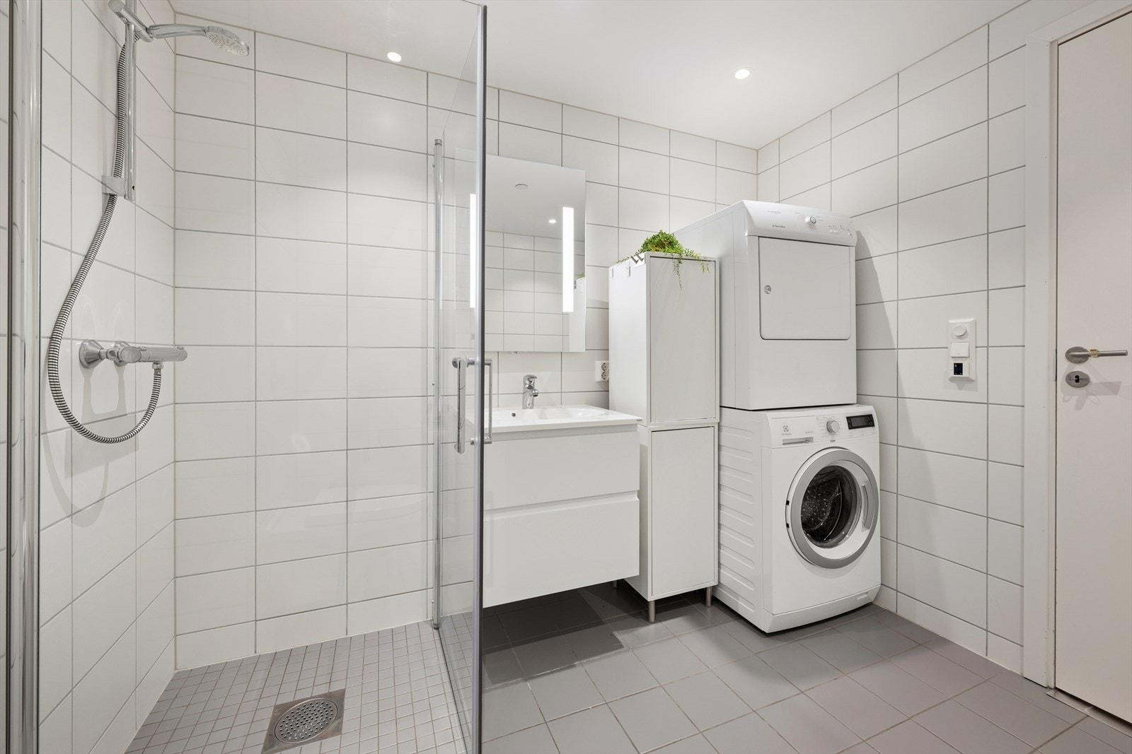 Flislagt baderom med elektriske varmekabler i gulvet og downlights i himlingen. Galleribilde