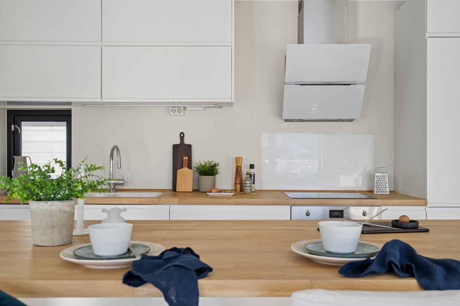 Det er etablert en fin og praktisk glassplate på vegg over benkeplaten, bak platetoppen. Galleribilde