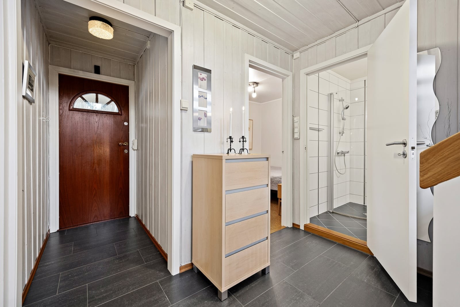 En hyggelig entré med elektriske varmekabler i gulvet. Her har du anledning til å henge fra deg yttertøy og sko før du går videre inn i boligen. Galleribilde