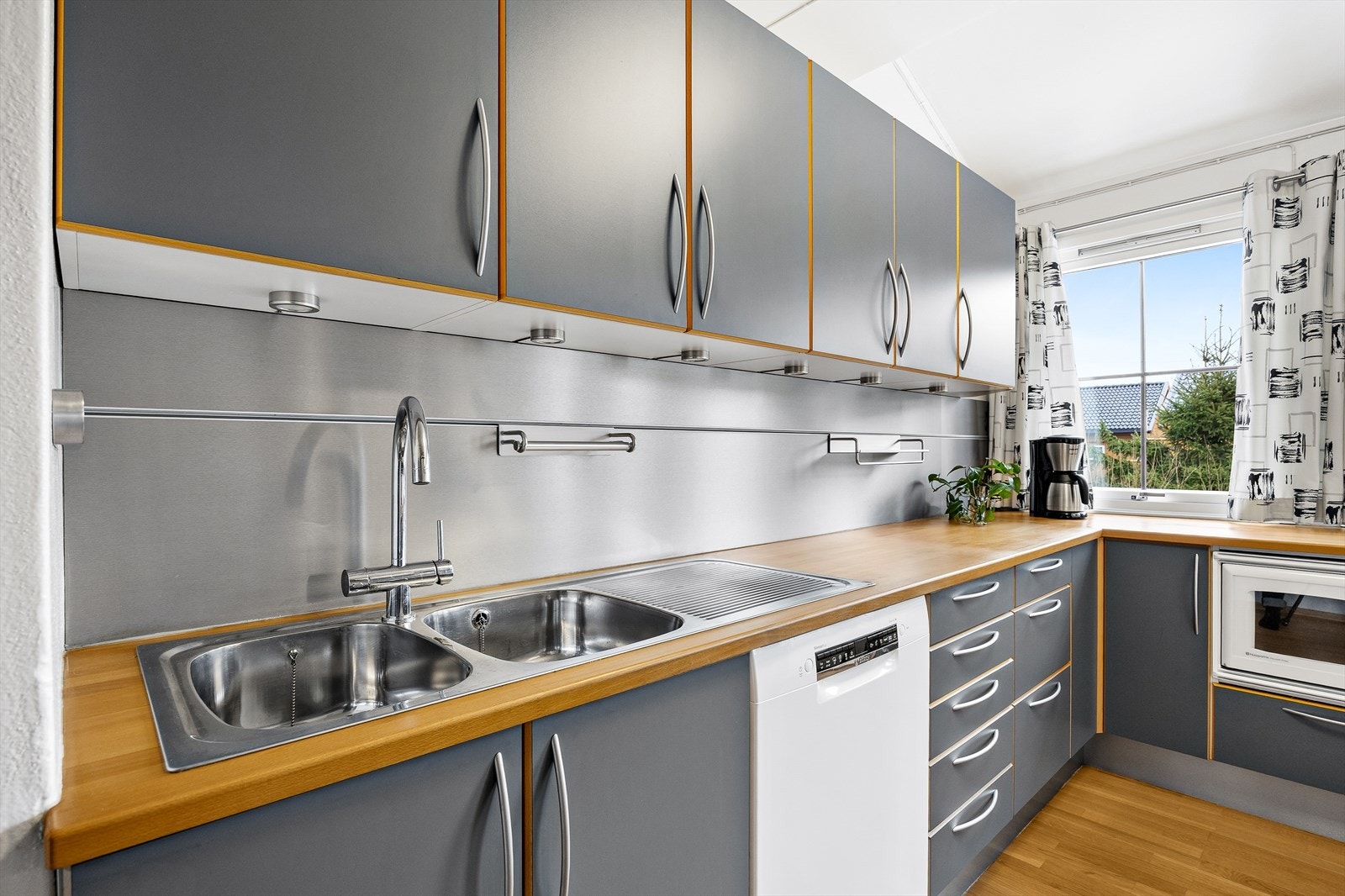 Kjøkkenet er innredet med kjøl/fryseskap, oppvaskmaskin fra 2025, integrert mikrobølgeovn, platetopp og stekovn Galleribilde