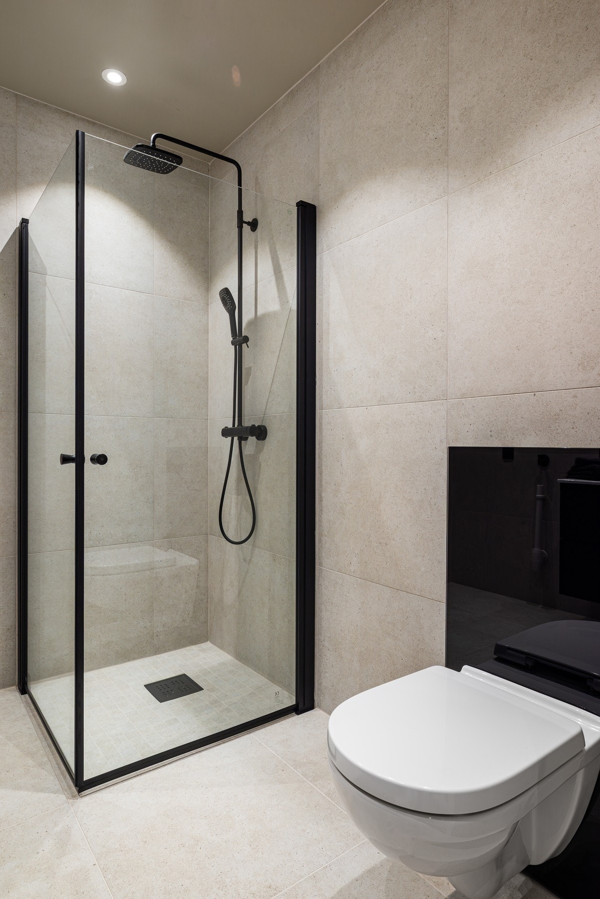 Dusjhjørne består av innfellbare dusjvegger, regnfallsdusj og fliser i samme farge som resten av badet. Galleribilde