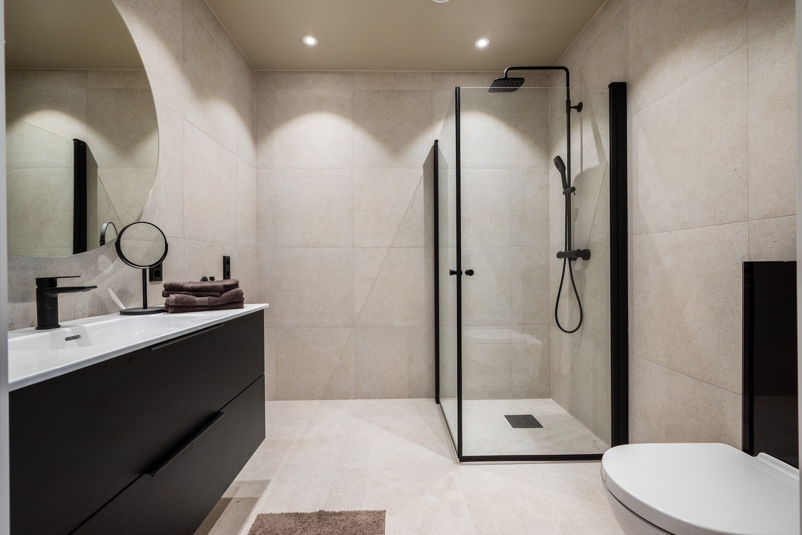 Her får du et stilrent og moderne bad på 5,3 kvm med 60x60 fliser, spotter i taket og varmekabler i gulvet. Galleribilde