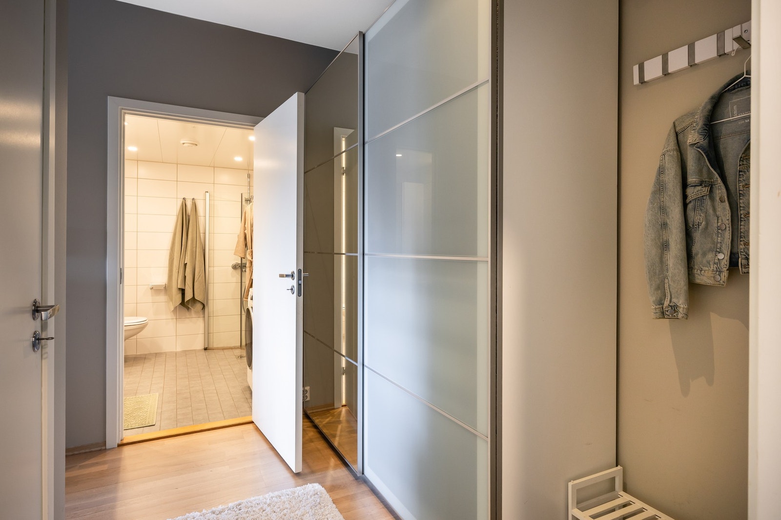 Lyst og innbydende inngangsparti med praktisk adkomst direkte til et flott flislagt bad rett frem. Galleribilde