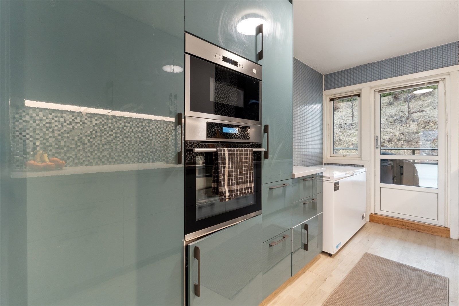 Kjøkkenet har nyere innredning med glatte fronter og en laminatbenkeplate som gir rommet et moderne og lyst uttrykk. Galleribilde