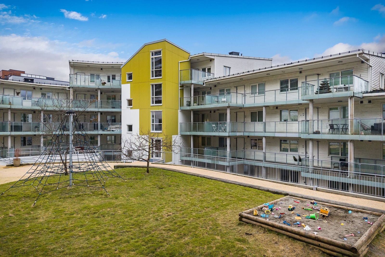 - Sameiets tre bygg danner et lunt tun med beplantning, gressplen og et trygt lekeområde for de minste - Galleribilde