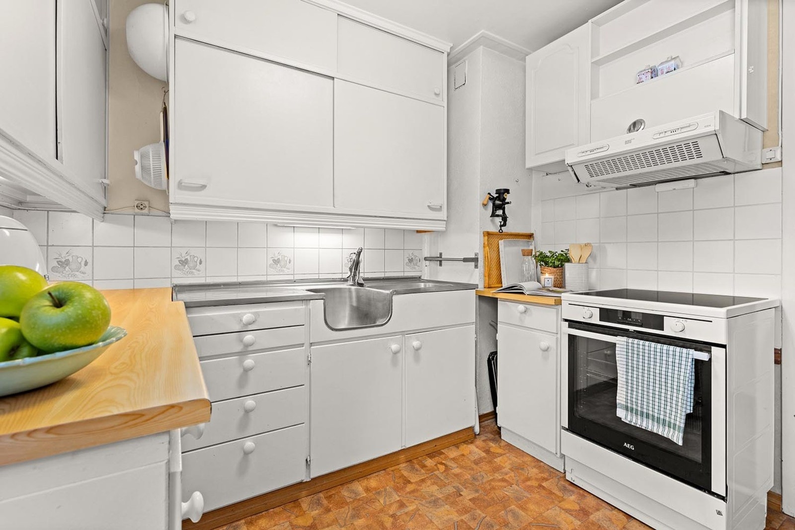 Kjøkkenet er utstyrt med frittstående komfyr, oppvaskmaskin og kjøleskap med fryser, samt ventilator integrert i overskap. Galleribilde