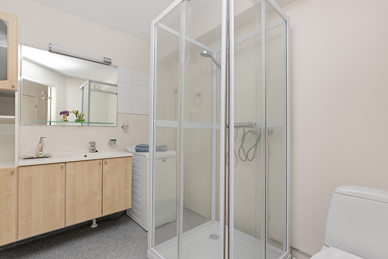 Dusjkabinett og gulvstående WC kompletterer våtrommet, som har mekanisk avtrekk via ventil i vegg. Galleribilde