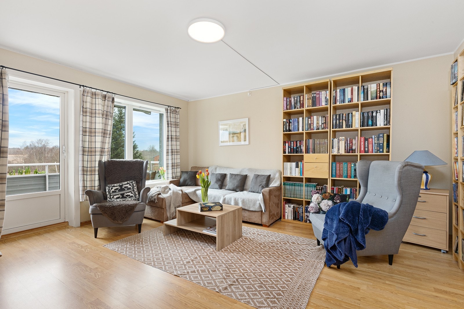 Store vindusflater i stuen gir utsyn mot grøntområder og enkel tilgang til balkongen. Galleribilde