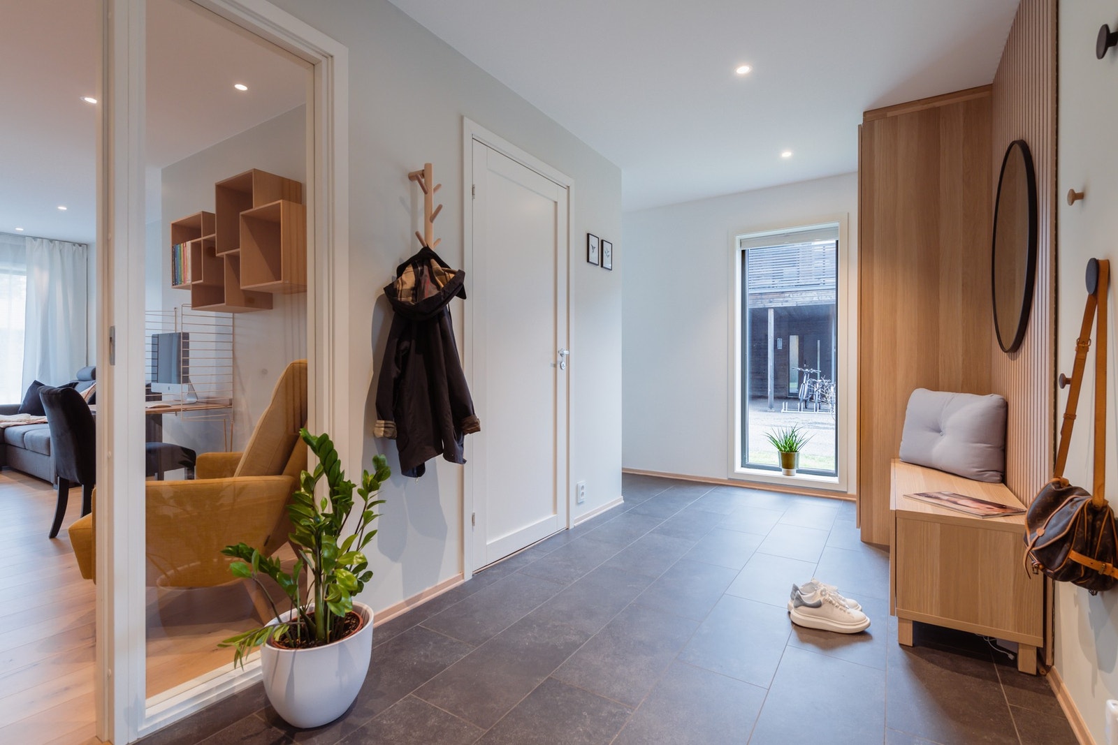 Stor flislagt gang med god plass til å henge fra seg yttertøy. Galleribilde