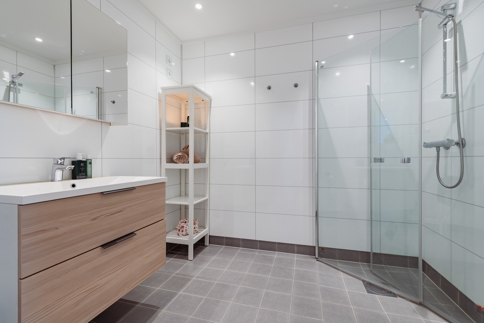 Bad i 1. etasje. Rommet inneholder: Servant med innredning, dusjhjørne og toalett. Galleribilde