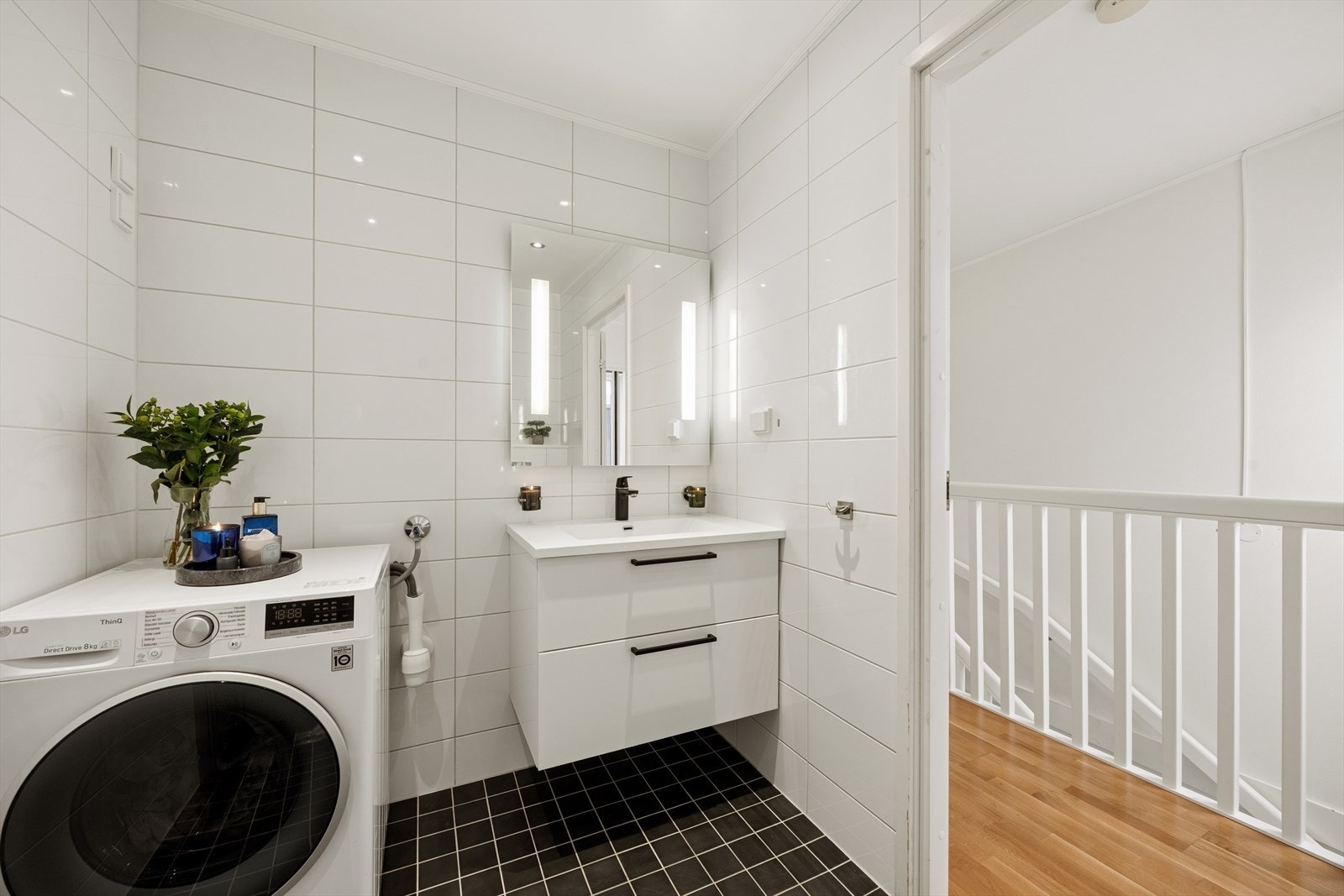 Videre er det svingbare dusjvegger i glass og opplegg for vaskemaskin. Det ble installert ny kran på vasken i 2025. Galleribilde