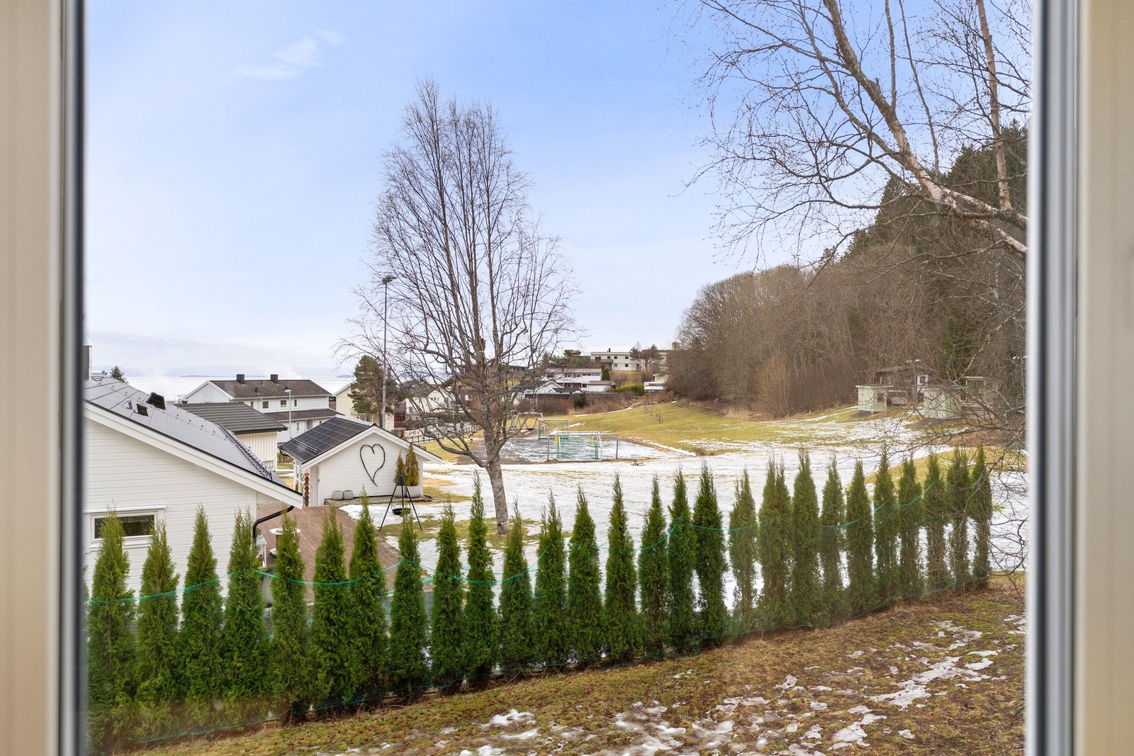 Fra kjøkkenvinduet har man utsikt til både lekeplass, gapahuk, fotballbane og akebakke som finnes i nabolaget. Galleribilde