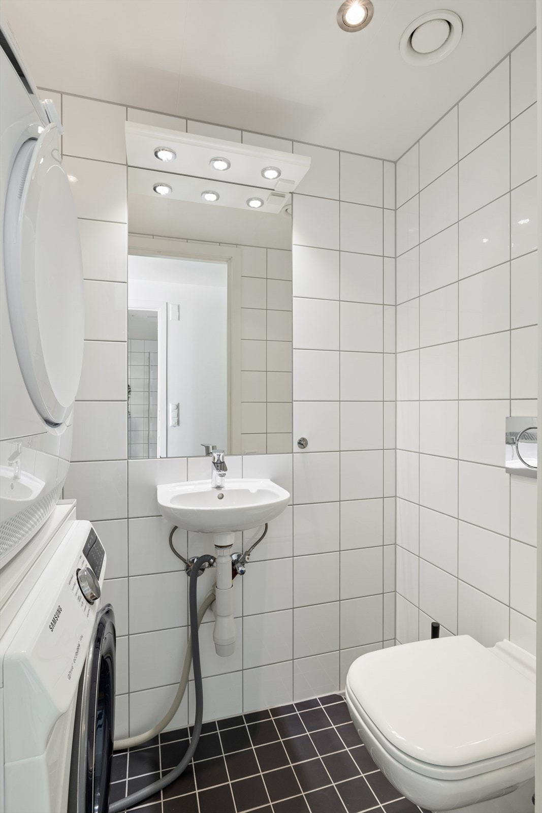Leiligheten har et praktisk, separat toalettrom med fliser på gulv og vegger. Opplegg for vaskemaskin. Galleribilde