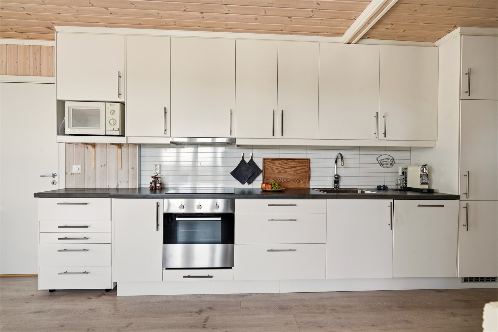 Kjøkkeninnredningen har glatte fronter, laminert benkeplate, vaskekum, nedfelt komfyrtopp, ventilator, stekeovn, oppvaskmaskin og kjøl/frys. Galleribilde