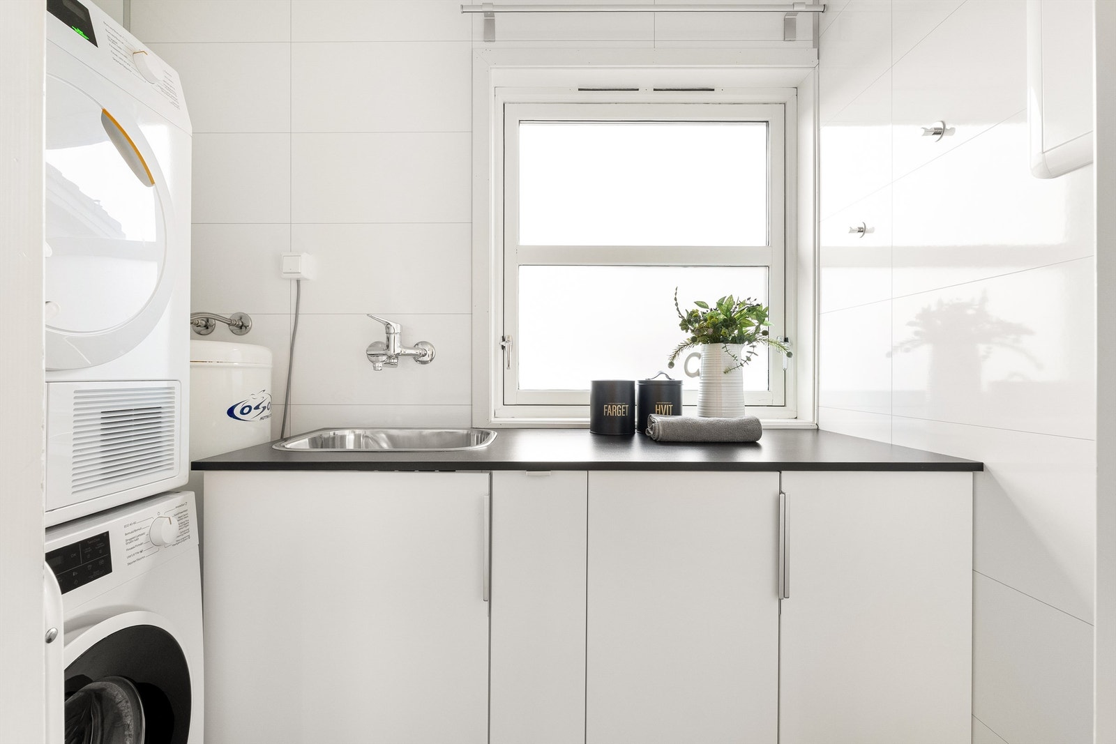 Vaskerom med våtromsbelegg på gulv, baderomspanel på vegger og malt platekledning i tak. Opplegg for vaskemaskin, sentral for rør-i-rør og 200L varmtvannsbereder. Galleribilde