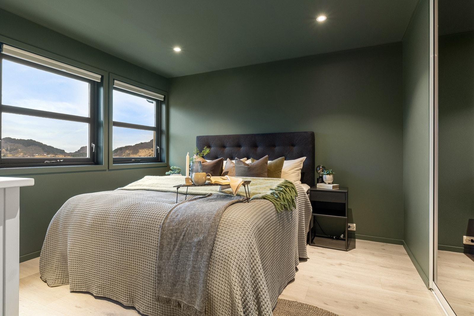 Innbydende soverom med laminatgulv og overflater malt i en flott grønnfarge. Galleribilde