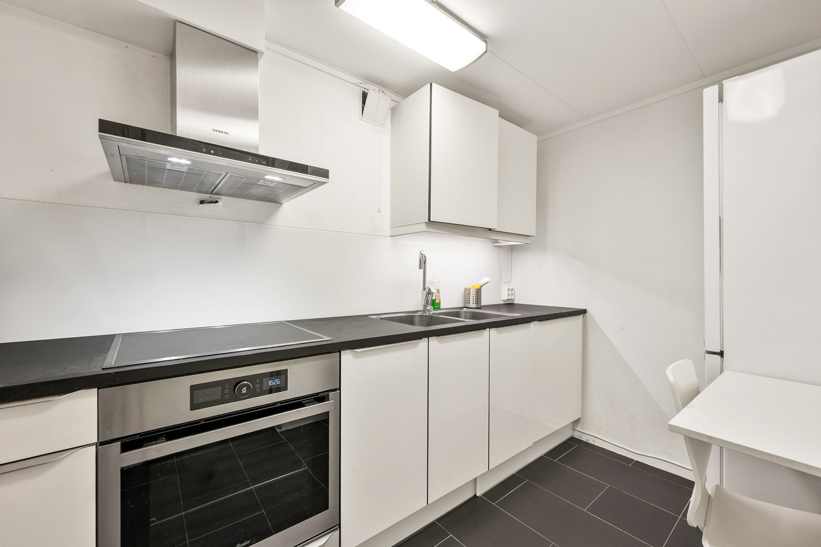 Kjøkkenet i kjeller med spiseplass har induksjonstopp, stekeovn, oppvaskmaskin og avtrekksvifte. Varmekabler i gulv. Galleribilde