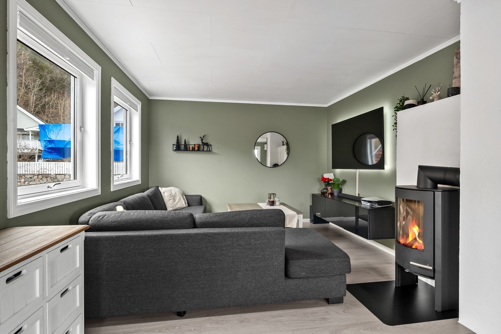 Stuen er vinklet slik at man har god plass til sofakrok. Peisovn. Galleribilde