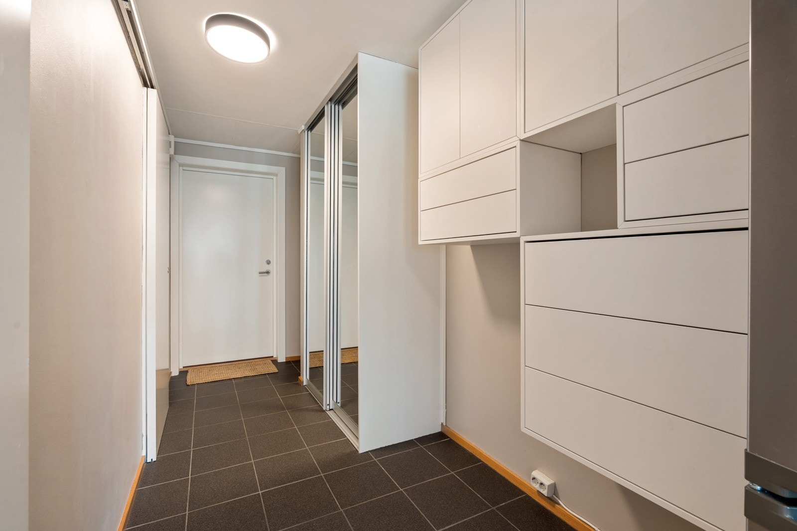 I entréen er det en stor skyvedørsgarderobe med speildører, og oppbevaringsmuligheter for klær og sko!