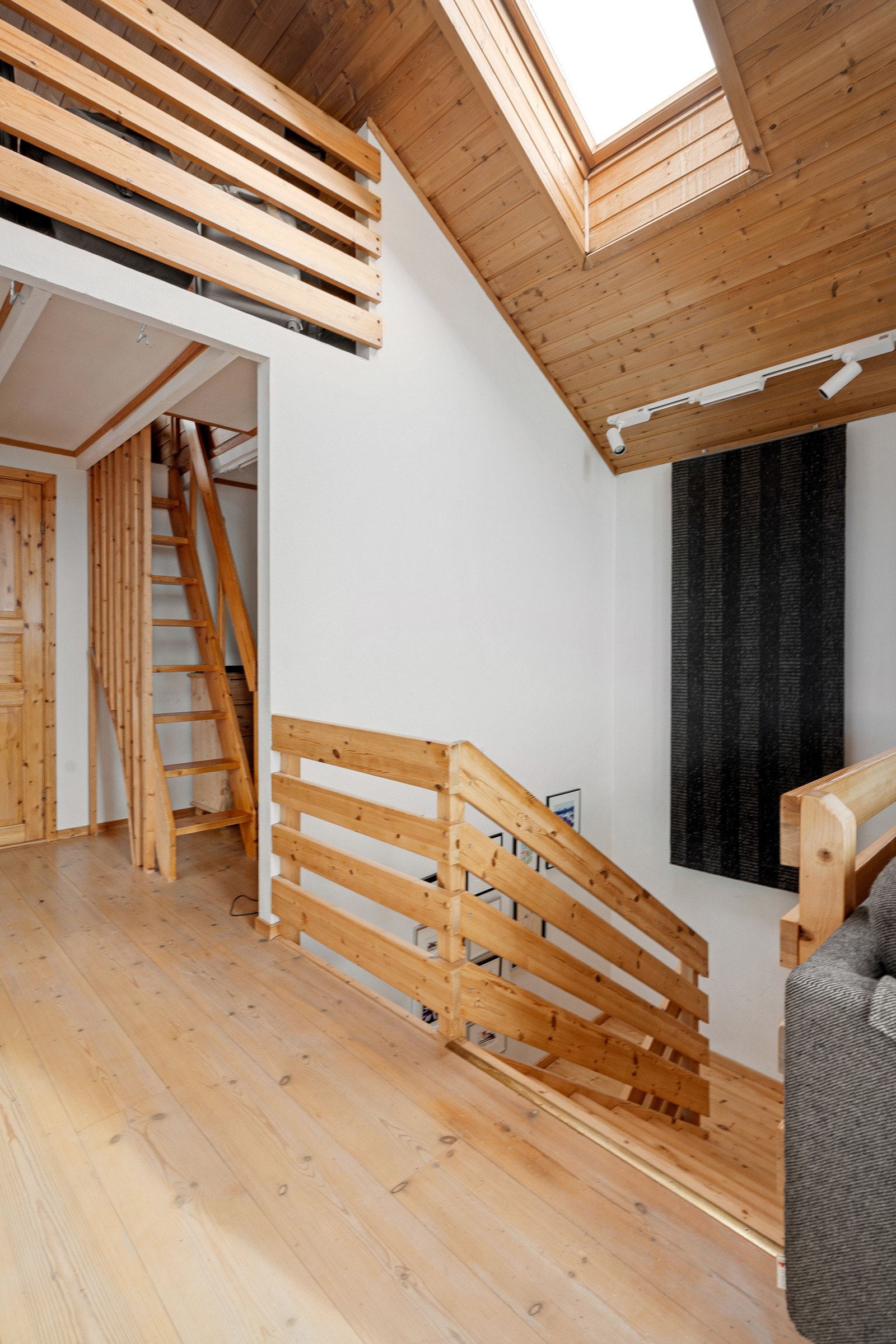 Gang/trapperom med vindu og lakkerte trinn mellom etasjene. Boligen har to innganger - en i hovedetasje og en til kjeller.