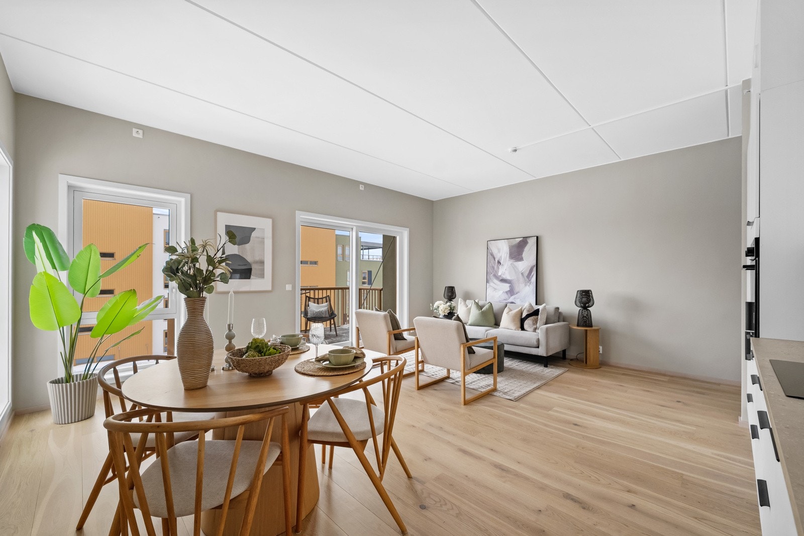 Leiligheten har en åpen og romslig stue- og kjøkkenløsning med 1-stavs eikeparkett og malte vegger i fargen Smoothing Beige. Galleribilde