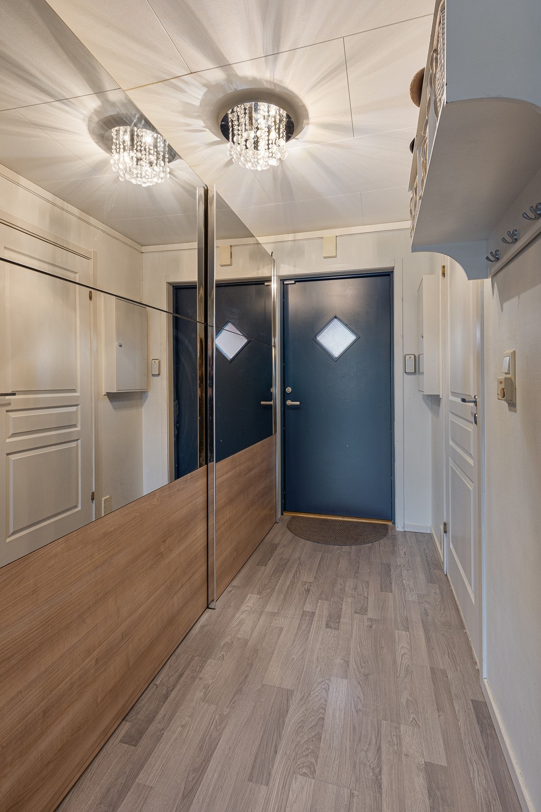 Entréen har lysmalte vegger og laminat på gulvet. Galleribilde