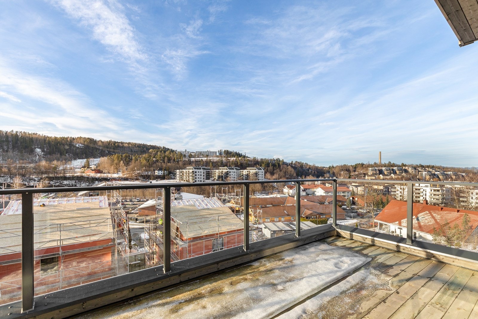 Balkongen er dekket med impregnert treverk og har glassrekkverk med stolper. Galleribilde