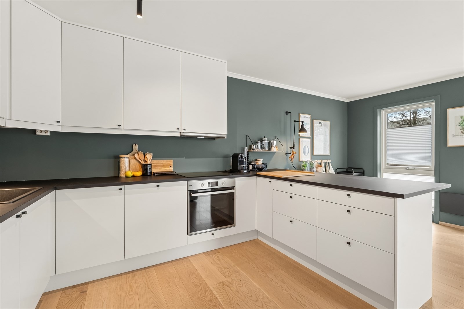 Kjøkkeninnredningen fra 2021 har slette, folierte fronter og en praktisk halvøy med ekstra benkeplass. Galleribilde