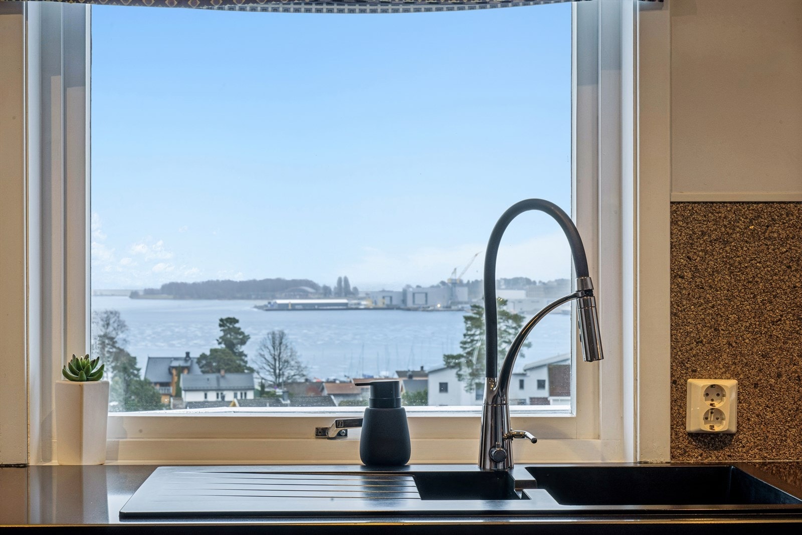 Fra kjøkkenbenken har man en flott utsikt over nærområdet og fjorden. Galleribilde